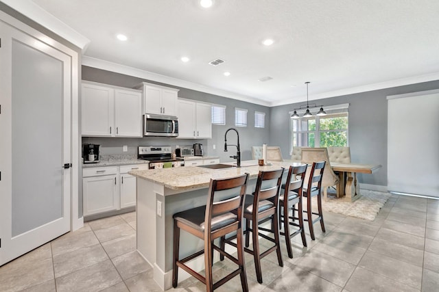 6449 NW Castlebrook Ave, Port Saint Lucie, FL 34983 - kitchen featuring a sink, appliances with stainless steel finishes, ornamental molding, and an island with sink