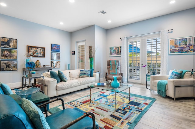 living room featuring visible vents, baseboards, recessed lighting, and wood finished floors