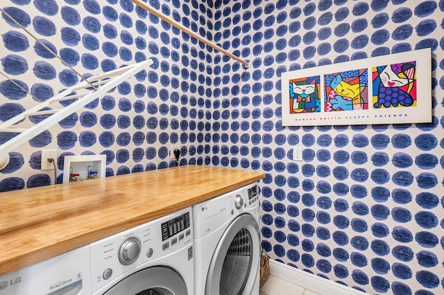 laundry area with independent washer and dryer, tile patterned flooring, laundry area, and baseboards