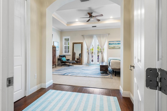entryway featuring a raised ceiling, arched walkways, french doors, and ornamental molding