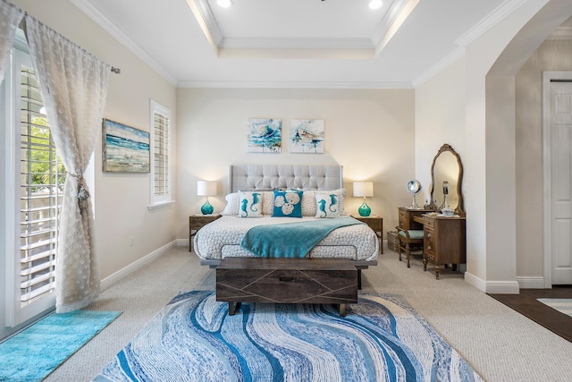 bedroom with crown molding, carpet floors, baseboards, and a raised ceiling