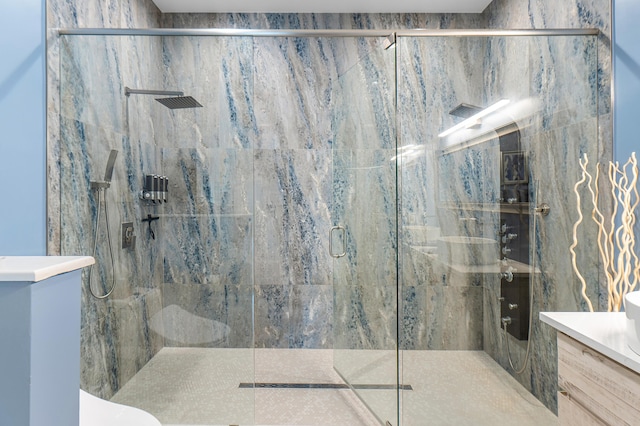 bathroom with toilet, a shower stall, and vanity