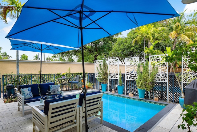 view of swimming pool featuring an outdoor living space, a patio area, and fence