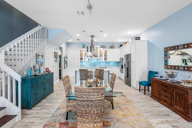 dining area featuring recessed lighting, stairs, and light wood finished floors