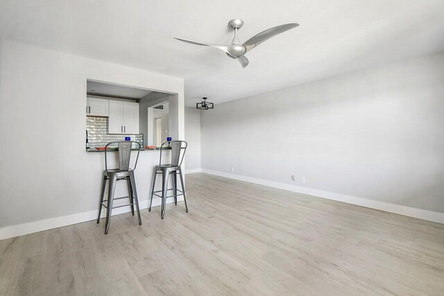 400 Village Green Cir W Unit 310, Palm Springs, FL 33461 - kitchen with tasteful backsplash, visible vents, a kitchen breakfast bar, white cabinets, and appliances with stainless steel finishes