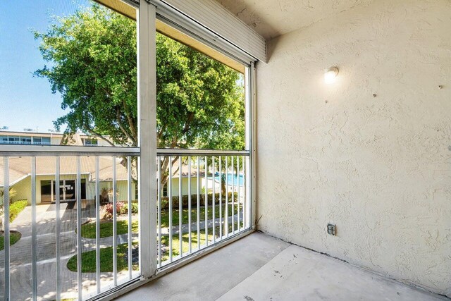 400 Village Green Cir W Unit 310, Palm Springs, FL 33461 - doorway to outside featuring concrete floors, plenty of natural light, and a textured wall