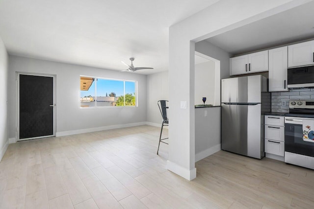 400 Village Green Cir W Unit 310, Palm Springs, FL 33461 - kitchen featuring stainless steel appliances, light wood-type flooring, white cabinetry, backsplash, and a ceiling fan
