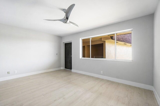 400 Village Green Cir W Unit 310, Palm Springs, FL 33461 - kitchen featuring stainless steel appliances, light wood-type flooring, white cabinetry, backsplash, and a ceiling fan