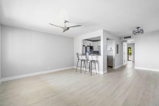400 Village Green Cir W Unit 310, Palm Springs, FL 33461 - living area with visible vents, baseboards, a ceiling fan, and light wood-style flooring
