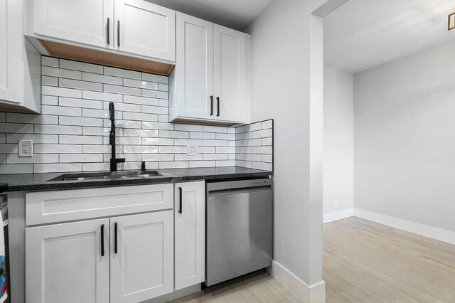400 Village Green Cir W Unit 310, Palm Springs, FL 33461 - kitchen with a sink, stainless steel appliances, decorative backsplash, dark countertops, and light wood-style floors