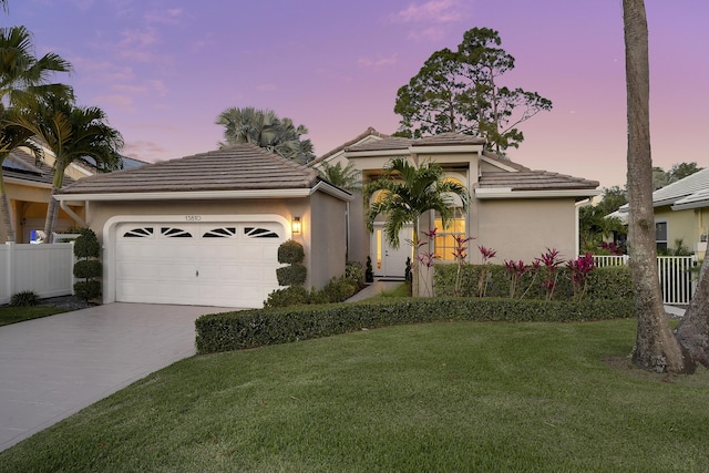 13810 Crosspointe Ct, Palm Beach Gardens, FL 33418 - mediterranean / spanish-style house with a lawn, driveway, an attached garage, and a tile roof