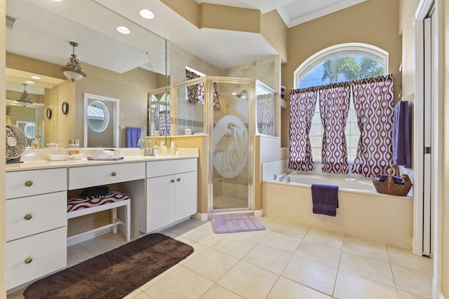 bathroom featuring tile patterned flooring, a bath, a shower stall, and vanity