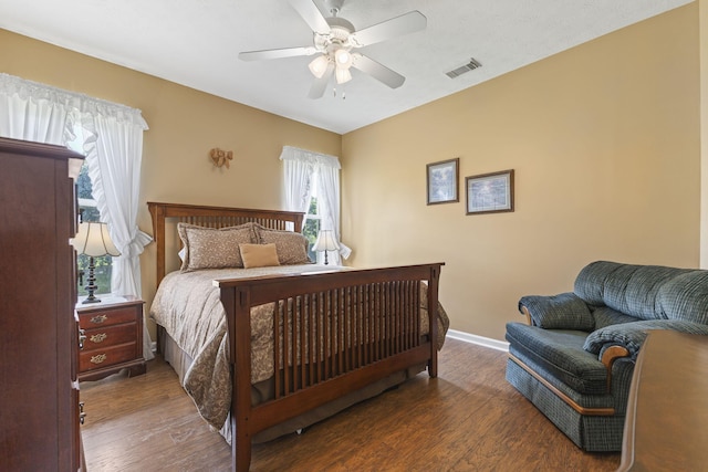 bedroom featuring wood finished floors, ceiling fan, baseboards, and visible vents