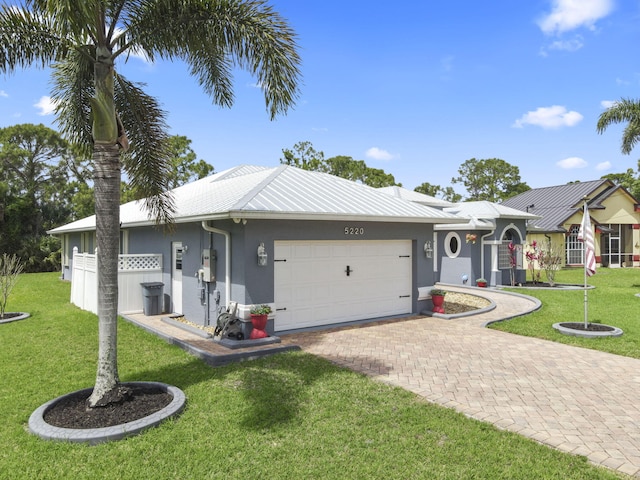 single story home featuring a garage, stucco siding, decorative driveway, and a front lawn