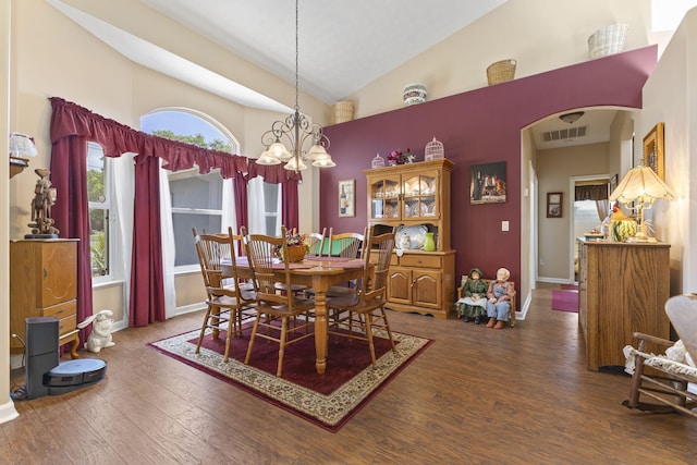 dining room with visible vents, arched walkways, a notable chandelier, wood finished floors, and high vaulted ceiling