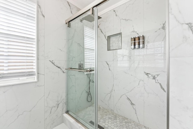 full bathroom with a marble finish shower and plenty of natural light