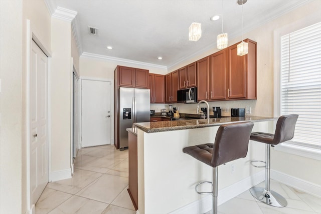 kitchen featuring baseboards, a kitchen bar, a peninsula, and stainless steel appliances