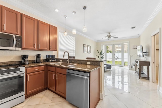 kitchen featuring a peninsula, ornamental molding, visible vents, appliances with stainless steel finishes, and a sink
