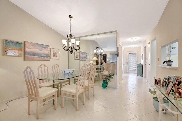 dining space with vaulted ceiling, an inviting chandelier, and light tile patterned flooring