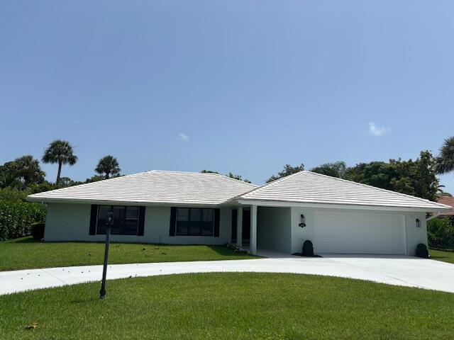 2831 SE Fairway W, Stuart, FL 34997 - ranch-style house with a garage, a front lawn, and driveway