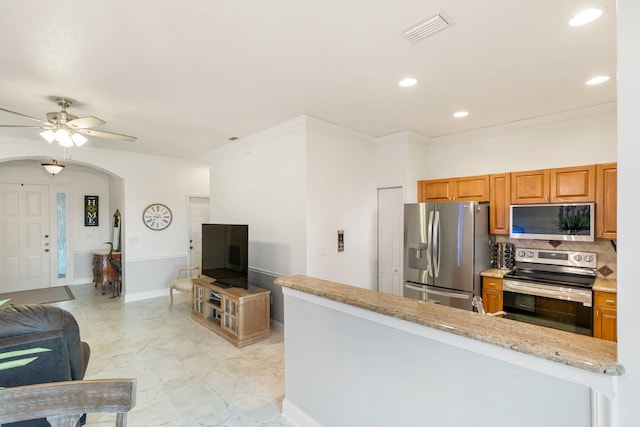 273 River Bluff Ln, Royal Palm Beach, FL 33411 - kitchen featuring stainless steel appliances, arched walkways, ceiling fan, ornamental molding, and brown cabinetry