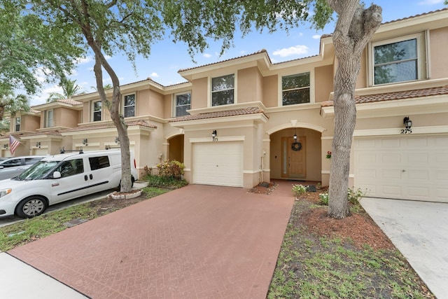 273 River Bluff Ln, Royal Palm Beach, FL 33411 - townhome / multi-family property with stucco siding, driveway, a tile roof, and a garage
