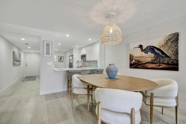 dining area with recessed lighting, baseboards, and light wood-type flooring