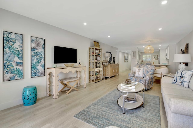 living area with light wood-style floors, baseboards, and recessed lighting
