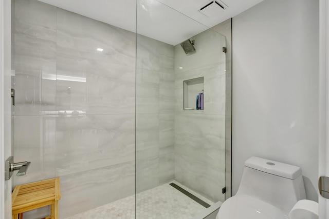 bathroom with toilet, walk in shower, and visible vents