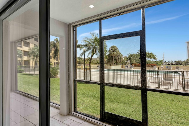 unfurnished sunroom featuring tile patterned flooring, a healthy amount of sunlight, and a wall of windows