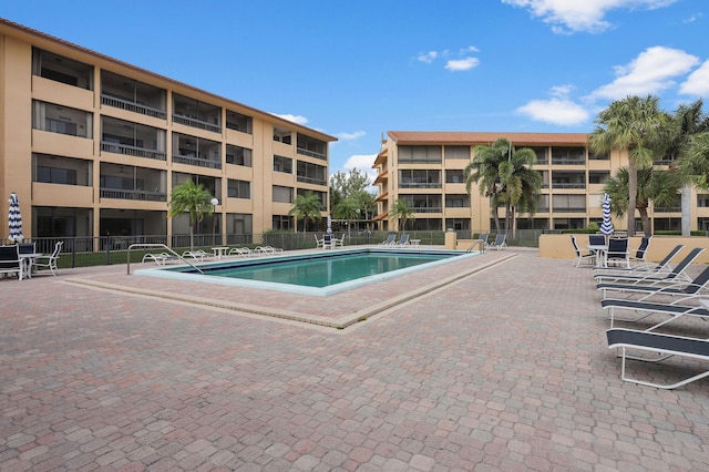 pool featuring fence and a patio area