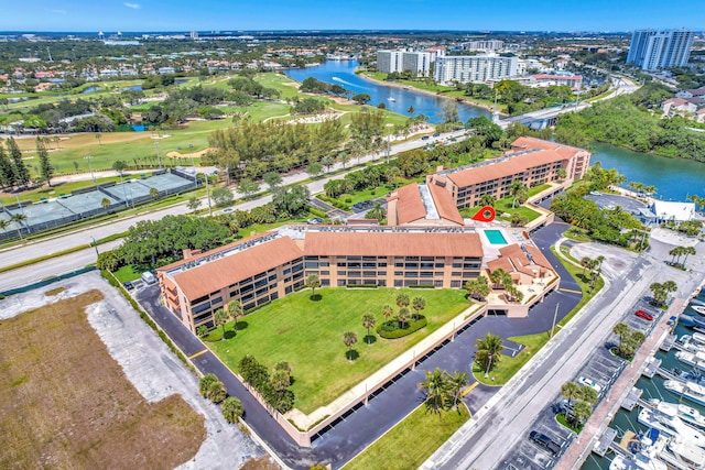 drone / aerial view featuring a city view, a water view, and golf course view