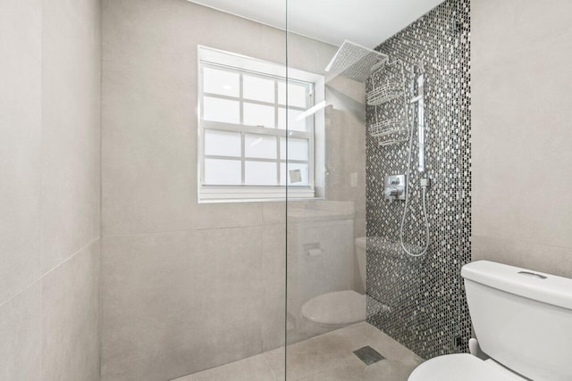 full bath featuring tile walls, toilet, and walk in shower