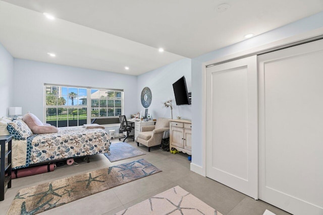 bedroom with concrete floors, a closet, and recessed lighting