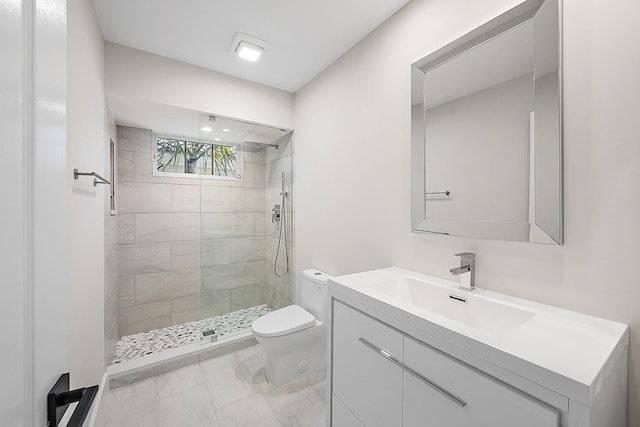 full bath with vanity, marble finish floor, a tile shower, and toilet