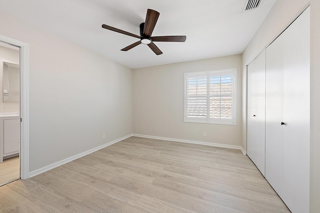 unfurnished bedroom featuring baseboards, visible vents, light wood-style flooring, and a closet