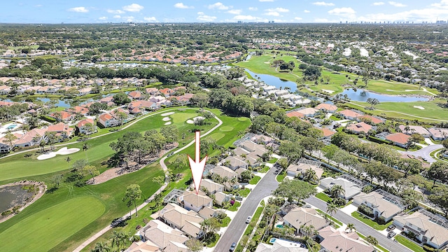 drone / aerial view featuring a water view, view of golf course, and a residential view