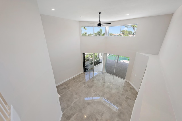 foyer entrance with baseboards, recessed lighting, ceiling fan, and a high ceiling