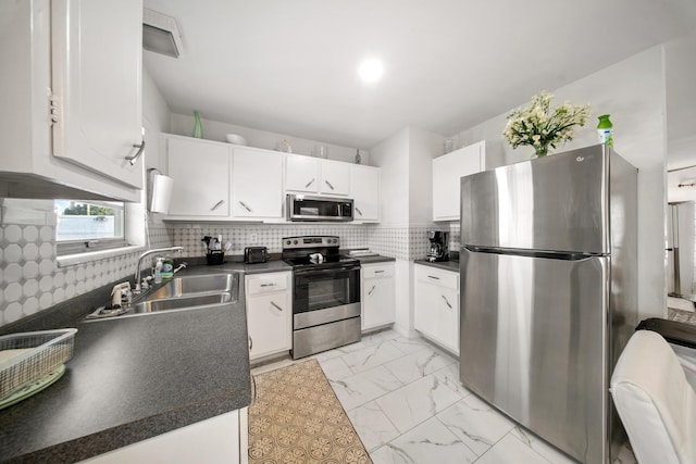 155 N Riomar Dr N, Port Saint Lucie, FL 34952 - kitchen featuring dark countertops, a sink, white cabinetry, and stainless steel appliances
