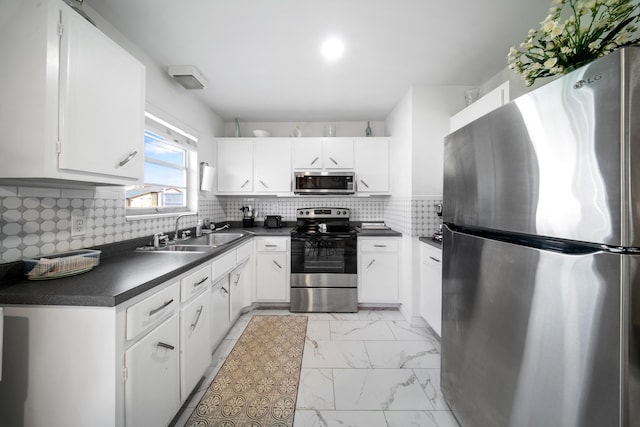 155 N Riomar Dr N, Port Saint Lucie, FL 34952 - kitchen with a sink, appliances with stainless steel finishes, dark countertops, white cabinetry, and marble finish floor