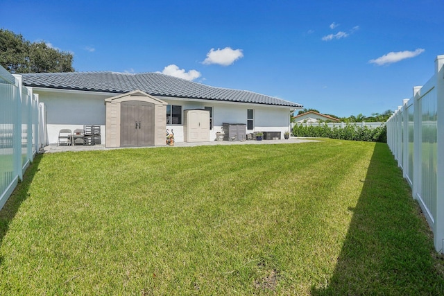 21830 Banyanwood Rd, Boca Raton, FL 33433 - rear view of property featuring a tiled roof, a yard, a fenced backyard, an outdoor structure, and a storage unit