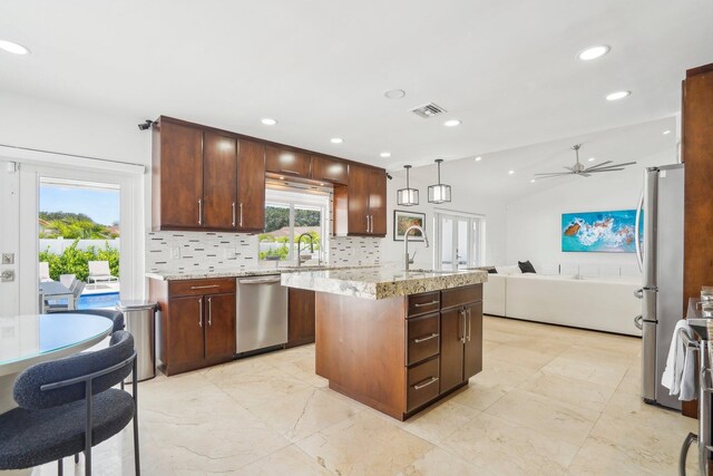 21830 Banyanwood Rd, Boca Raton, FL 33433 - kitchen featuring tasteful backsplash, open floor plan, a kitchen island with sink, visible vents, and appliances with stainless steel finishes