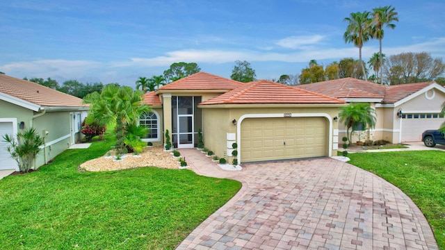 mediterranean / spanish home featuring a tile roof, decorative driveway, an attached garage, a front yard, and stucco siding