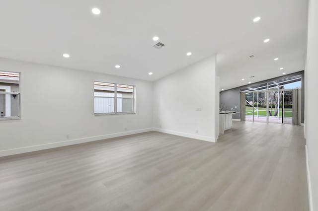 empty room with recessed lighting, visible vents, light wood finished floors, and baseboards