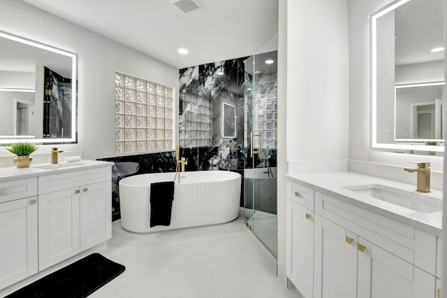 bathroom featuring a soaking tub, visible vents, a sink, and recessed lighting