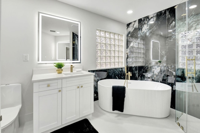full bath with vanity, recessed lighting, a soaking tub, and tile walls