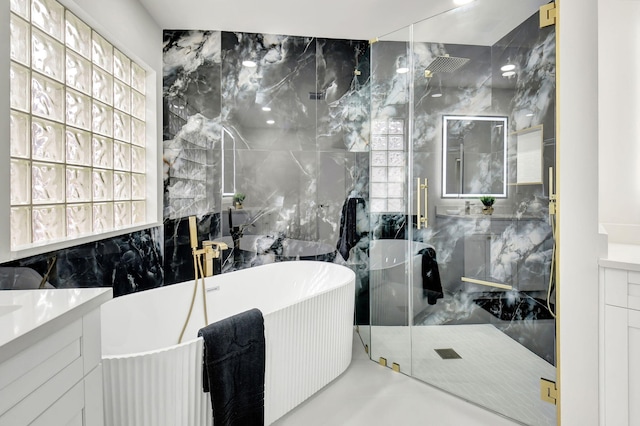 bathroom with a freestanding bath, tile walls, vanity, and a stall shower