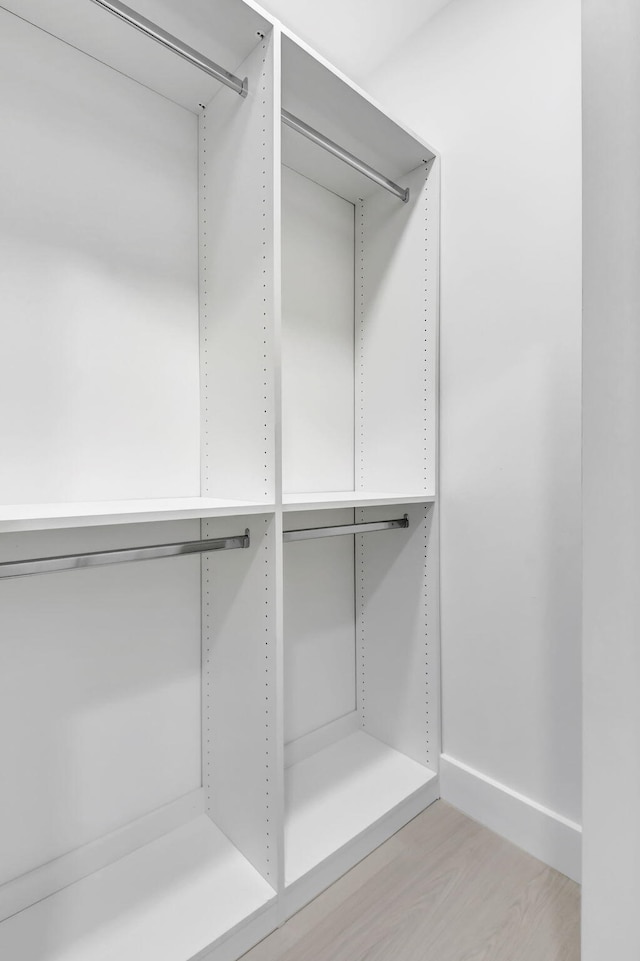walk in closet with light wood-style floors