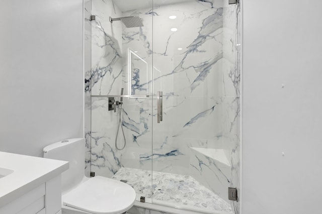 bathroom with toilet, vanity, and a marble finish shower