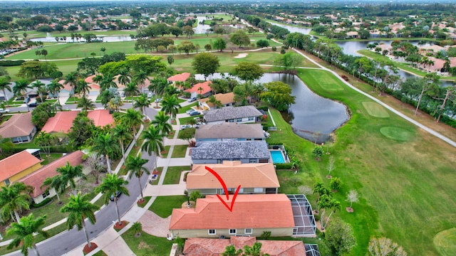 drone / aerial view featuring a residential view, golf course view, and a water view